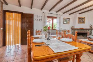 a dining room with a wooden table and a fireplace at Casa Torre del Manzano in Torrox