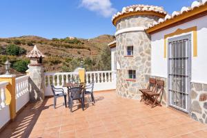 a patio with a table and chairs on a balcony at Casa Torre del Manzano in Torrox