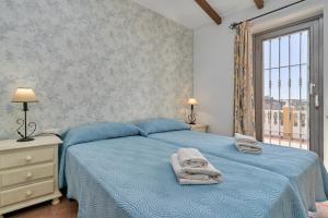 a bedroom with a blue bed with towels on it at Casa Torre del Manzano in Torrox +25 photos