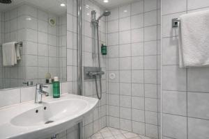 a white bathroom with a sink and a shower at Thon Hotel Sortland in Sortland +28 photos
