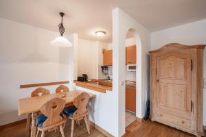 a kitchen and dining room with a wooden table and chairs at Fewo Brünnstein - Nr 46 Pool, Sauna in Oberaudorf