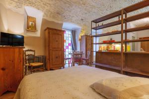a bedroom with a bed and a tv in a room at Studio De Caractère Classé 3 in Les Vans