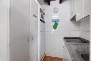a kitchen with a refrigerator and a sink at Pedras Del Rei 26 in São Pedro +12 photos