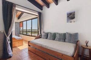 a bedroom with a bed with a view of the ocean at Pedras Del Rei 26 in São Pedro