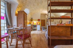 a kitchen and dining room with a table and bunk beds at Studio De Caractère Classé 3 in Les Vans