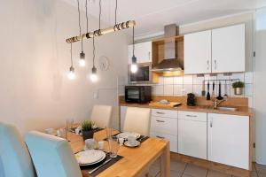 a kitchen and dining room with a wooden table at Nordseezeit Strandnah u Poolrabatt in Butjadingen +19 photos