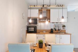 a kitchen with a table with chairs and a microwave at Nordseezeit Strandnah u Poolrabatt in Butjadingen