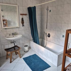 a bathroom with a tub and a sink and a shower at Ferienwohnung Kleine Pause in Emmendingen +6 photos