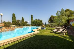 a swimming pool in a yard with two lounge chairs next to it at Villa La Guaita in Ríudecañas