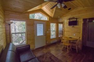 a living room with a table and a ceiling fan at Lake of the Springs Camping Resort Cottage 1 in Oregon House