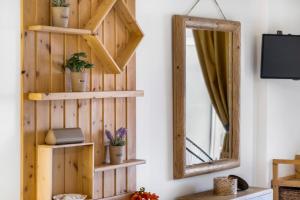 a room with a mirror and a wooden wall at Oceanida Aelia room in Nikiana