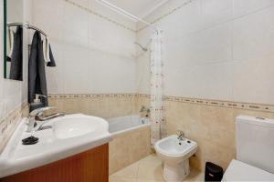 a bathroom with a sink and a toilet and a tub at Tourismer Centro 31 in Lagos +15 photos