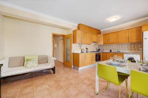 a kitchen and living room with a couch and a table at Tourismer Centro 31 in Lagos