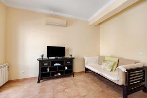 a living room with a couch and a tv at Tourismer Centro 31 in Lagos