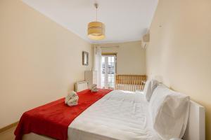 a bedroom with a large white bed with a red blanket at Tourismer Centro 31 in Lagos