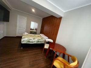 a bedroom with a bed and a table and a chair at Hotel Atenas in Barranca +1 photo