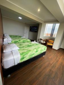 a hotel room with two beds and a table at Hotel Atenas in Barranca