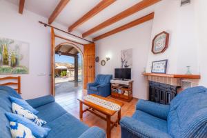 a living room with two blue couches and a fireplace at S'alqueria Vell in Campanet