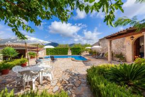 a patio with a table and chairs and a pool at S'alqueria Vell in Campanet