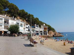 a beach with a bunch of people on the beach at La Barraca de Farena in Palafrugell