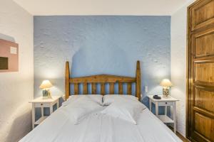 a bedroom with a large white bed with two tables at La Barraca de Farena in Palafrugell