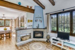 a living room with a fireplace and a tv at La Barraca de Farena in Palafrugell