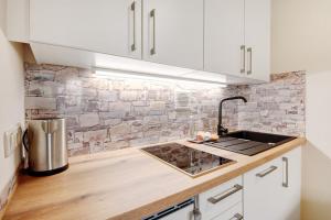 a kitchen with white cabinets and a counter with a sink at Ferienappartement Waldgenuss in Sankt Englmar