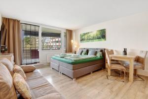 a living room with a bed and a table at Ferienappartement Waldgenuss in Sankt Englmar +21 photos