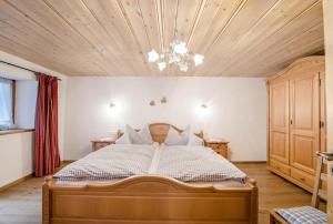 a bedroom with a bed and a wooden ceiling at Ferienwohnung Waxenstein in Grainau