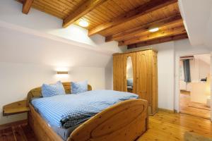 a bedroom with a wooden bed in a room with wooden ceilings at Idyllisches Bauernhaus in Gerswalde
