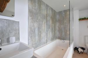 a bathroom with a white tub and a sink at 3 Bed in Brecon oc-93680 in Llandefalle +32 photos