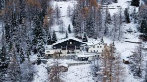 a house in the middle of a snow covered forest at Waldhotel Fletschhorn Private Whole Hotel in Saas-Fee 360 Alpine Views & Sauna in Saas-Fee