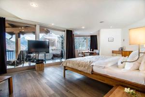 a bedroom with a large bed and a large window at Waldhotel Fletschhorn Private Whole Hotel in Saas-Fee 360 Alpine Views & Sauna in Saas-Fee