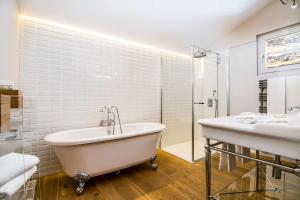 a white bathroom with a tub and a sink at Waldhotel Fletschhorn Private Whole Hotel in Saas-Fee 360 Alpine Views & Sauna in Saas-Fee