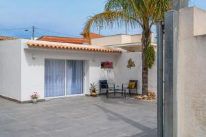 a patio with a palm tree and a house at La casa di Susy in Avola