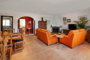 a living room with orange chairs and a table at Casa La Mirada in Cómpeta