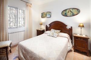 a bedroom with a bed and two lamps and a window at Casa La Mirada in Cómpeta +37 photos