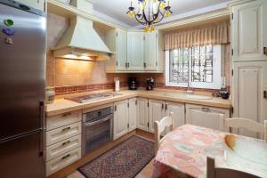 a kitchen with white cabinets and a table and a sink at Casa La Mirada in Cómpeta