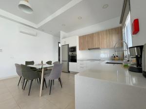 a white kitchen with a table and chairs in it at Villa Lychee in Playa Blanca