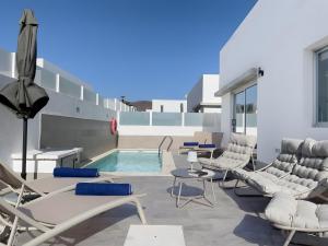 a patio with chairs and a swimming pool at Villa Lychee in Playa Blanca