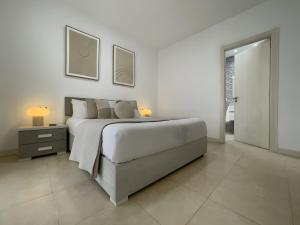 a white bedroom with a large bed and a nightstand at Villa Lychee in Playa Blanca +15 photos