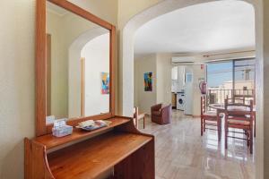 a living room with a mirror and a dining room at Casa Enxame in Armação de Pêra