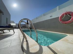 a swimming pool with a slide in a house at Villa Lychee in Playa Blanca