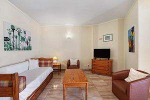 a living room with a couch and a tv at Casa Enxame in Armação de Pêra