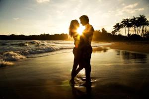 a man and woman kissing on the beach at Sealodge A2 Romantic Ocean View Oasis with Pool in Princeville