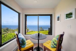 a room with a table and chairs and a view of the ocean at Sealodge A2 Romantic Ocean View Oasis with Pool in Princeville