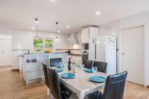 a dining room with a table and chairs and a kitchen at Villa Sueños in Marratxí 