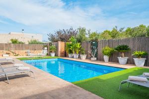 a swimming pool in a backyard with chairs and plants at Villa Sueños in Marratxí 