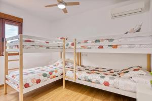 two bunk beds in a room with a ceiling fan at Violeta Grande in Macastre +20 photos