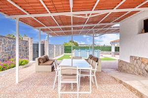 a patio with a table and chairs under a pergola at Violeta Grande in Macastre